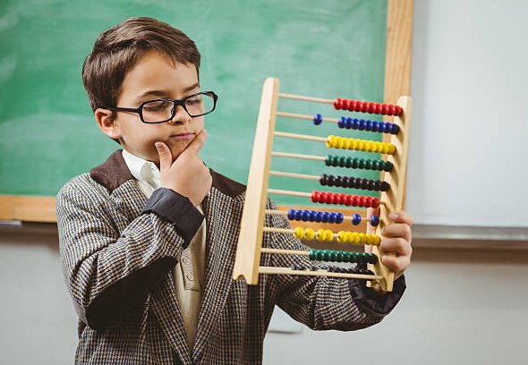 Pupil dressed up as teacher holding abacus in a classroom